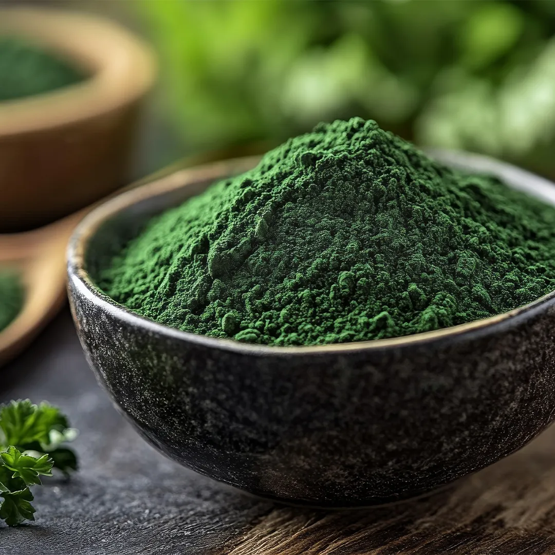 rubyni® Vitamin K: Unterstützung für starke Knochen Petersilienpulver in einer Kokosschale auf einem Holztisch. Daneben liegt ein Petersilienblatt. Man sieht verschwommen im Hintergrund einen kleinen Holzlöffel mit grünem Pulver sowie eine weitere Holzschale mit grünem Pulver.