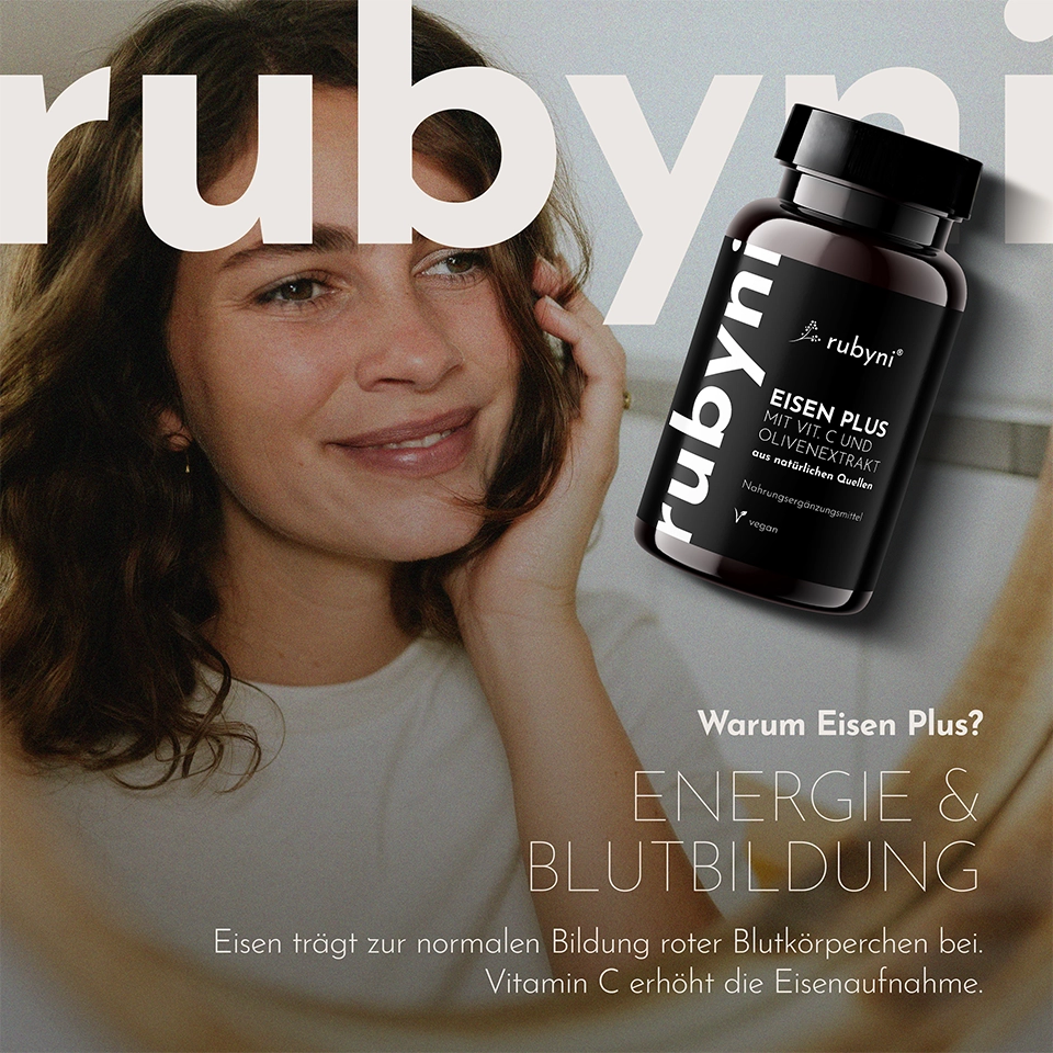 Frau betrachtet sich im Spiegel, während daneben die rubyni PET-Dose „Eisen Plus“ mit Vitamin C und Olivenextrakt schwebend dargestellt ist und die Vorteile für Energie und Blutbildung hervorgehoben werden.