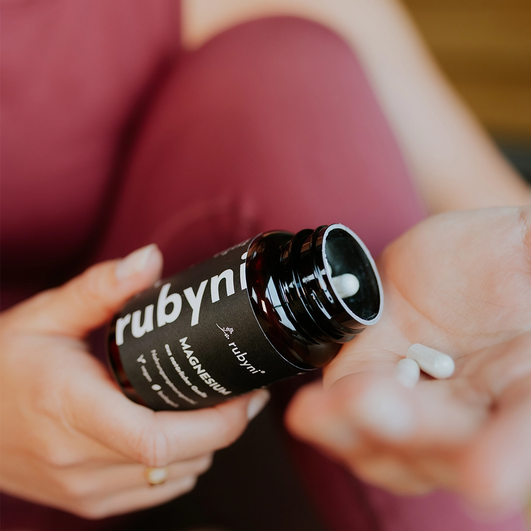 Produktabbildung „rubyni® Omega 3 Algenöl Zitrone DHA + EPA“: Braune Glasflasche mit schwarzem Schraubverschluss und schwarzem Etikett vor hellem Hintergrund. Auf dem Etikett stehen Produktname, „aus natürlicher Quelle“, „Nahrungsergänzungsmittel“ sowie der Hinweis „vegan“.
