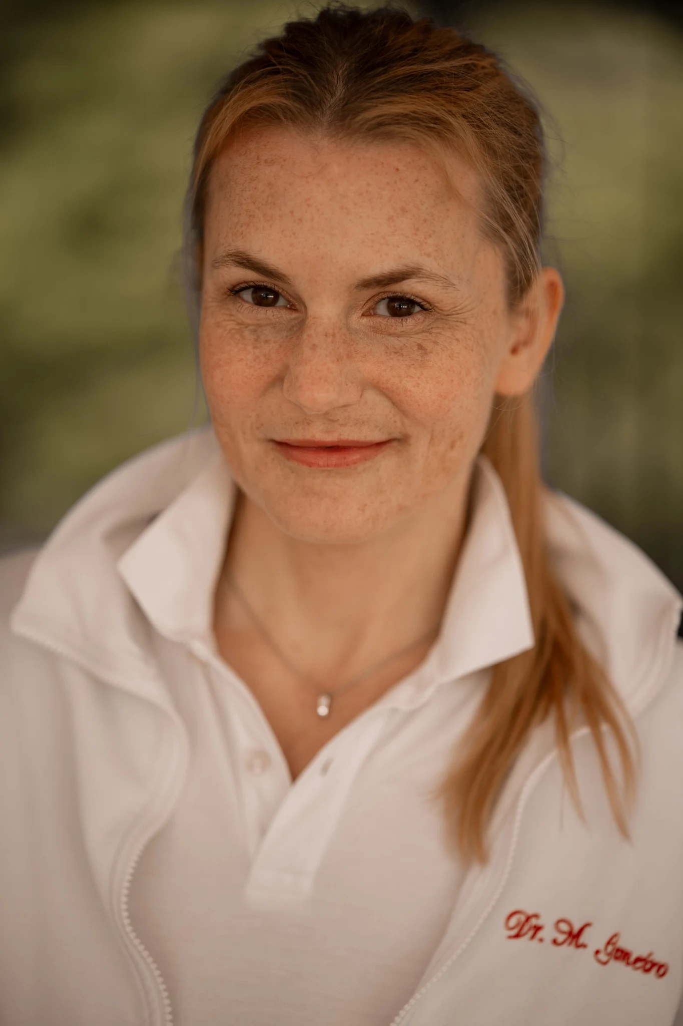 Porträt von Dr. Magdalena Gameiro in weißer medizinischer Berufskleidung.